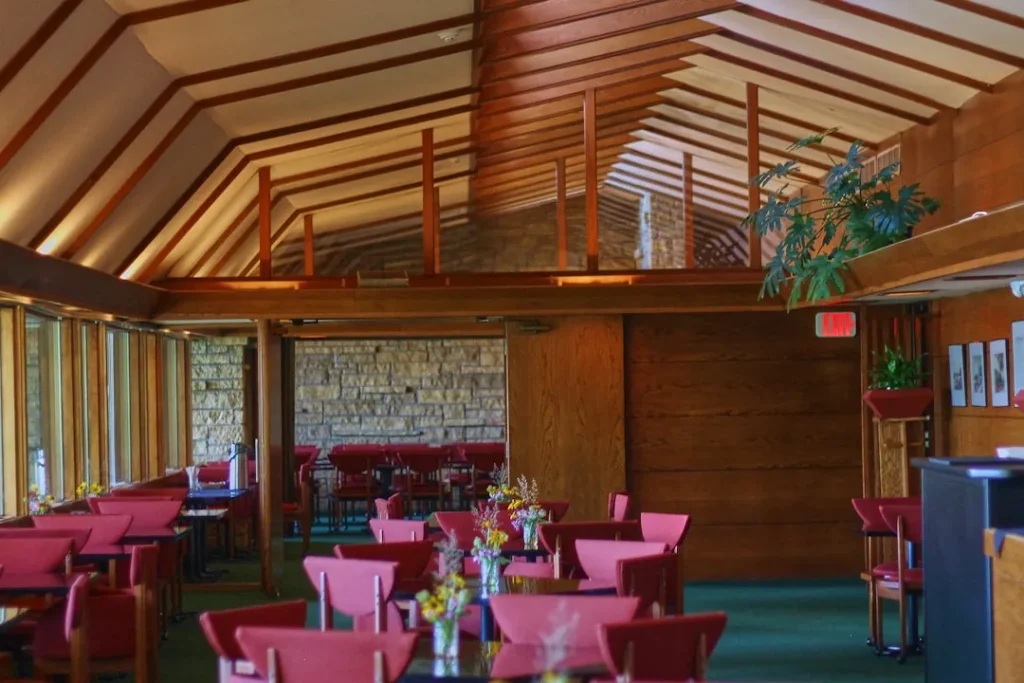 Restaurant interior with red chairs and wooden beams.