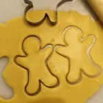 a cookie cutter next to some cut out cookies