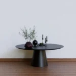 a black table with two vases on top of it