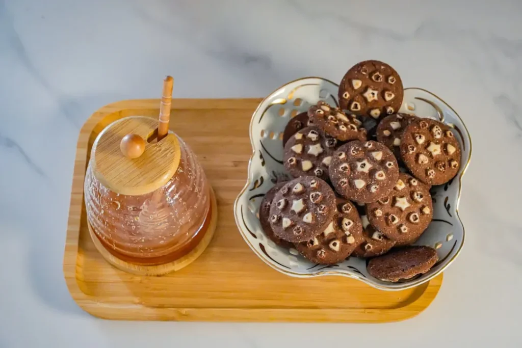 Chocolate cookies with hazelnuts and a honey pot
