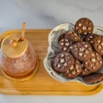 Chocolate cookies with hazelnuts and a honey pot